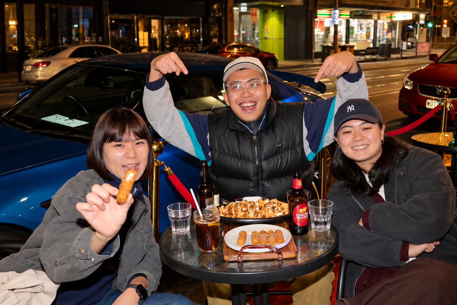Three guests sharing plates and drinks at Illumina's outdoor tables